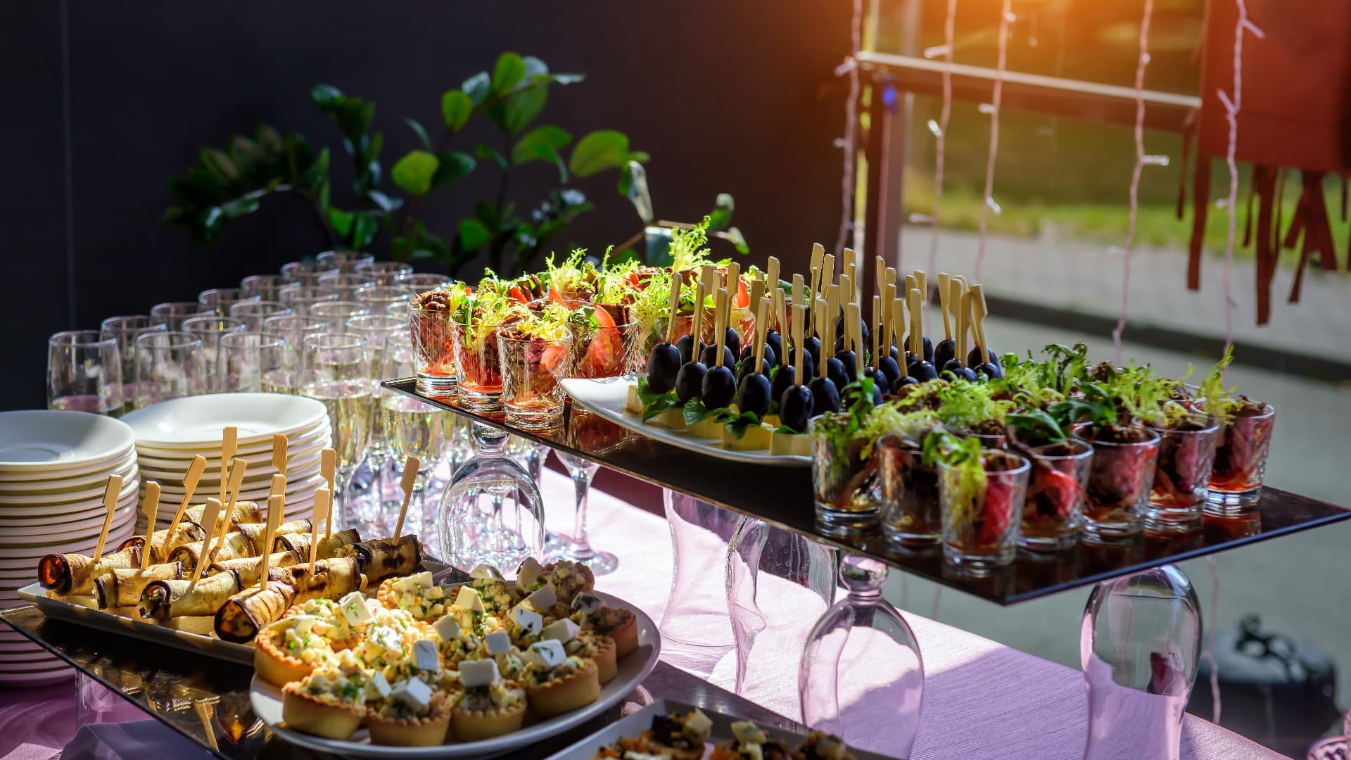 Cold appetizers at banquet, restaurant service, catering. Variety of delicious starters on wooden skewers and salads in small tartlets.